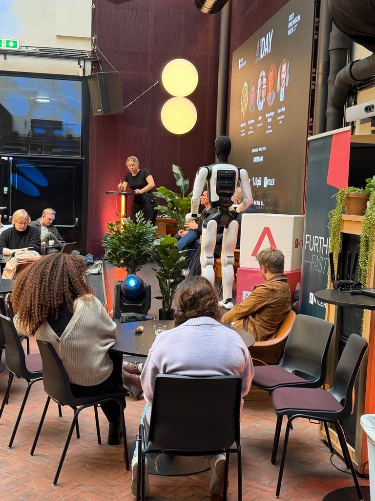 Panelsamtale på AI Day i Oslo med den humanoide roboten Wybe på scenen.