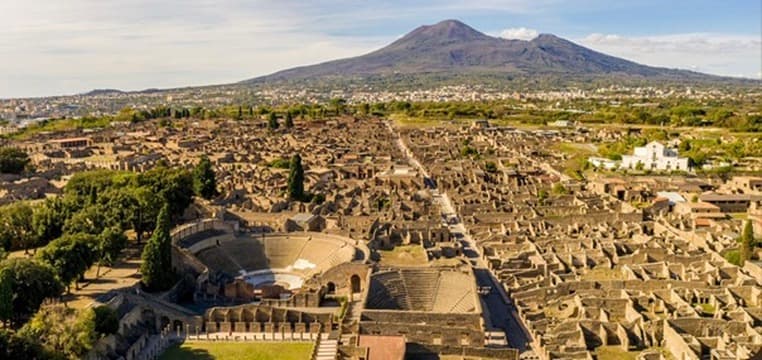 Oversikt over ruinene i Pompeii med Vesuv i bakgrunnen.