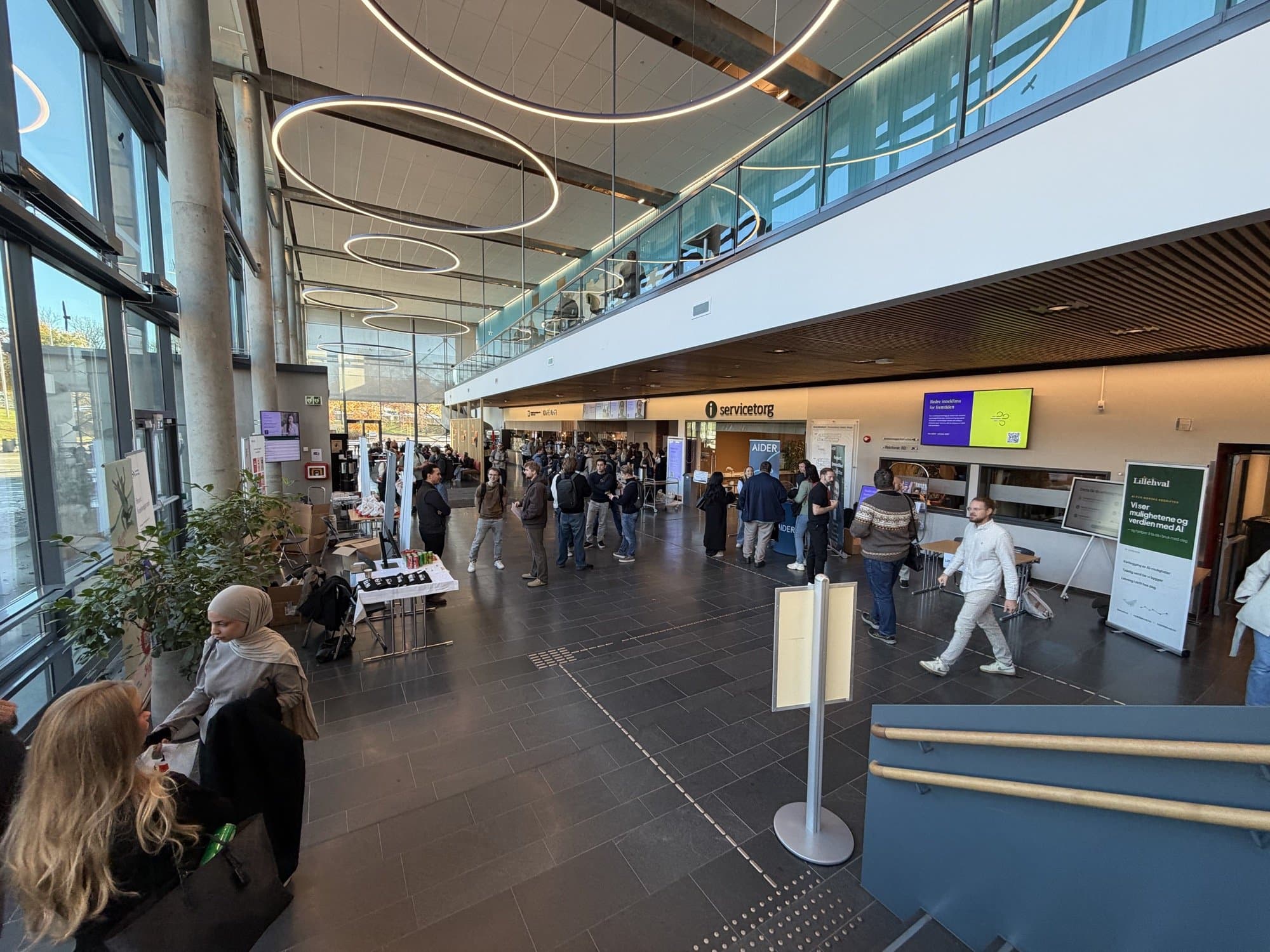 Oversikt over vestibylen på USN Bakkenteigen med stands og studenter, og Lillehvals roll-up til høyre.